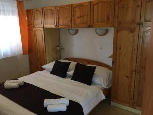 a bedroom with a large bed with wooden cabinets at Central Apartments in Zalakaros