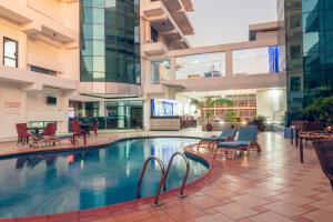 an indoor pool in a building with chairs and tables at Peacock Hotel in Dar es Salaam