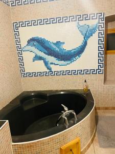 Baño con lavabo y pared de mosaico en Appartement au calme au milieu du vignoble de Gigondas, en Gigondas