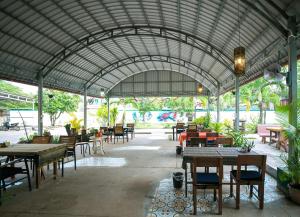 a restaurant with tables and chairs and a large roof at Villa Kampot Cafe in Kampot