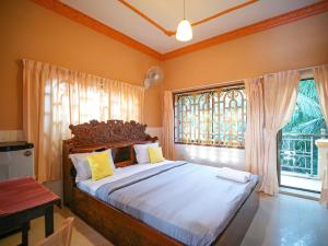 a bedroom with a large bed and a window at Villa Kampot Cafe in Kampot