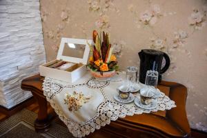 een tafel met een tafelkleed en een theeset bij Flower Apartment - Standard in Odorheiu Secuiesc