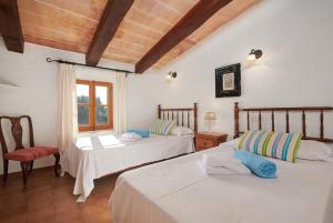 a bedroom with two beds and a chair and a window at Finca Son Oliver by Mallorca House Rent in Felanitx +42 photos