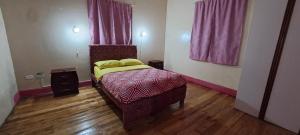 1 dormitorio pequeño con 1 cama y 2 ventanas en Magic Hostal, en Quito