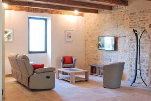 a living room with a couch and a chair at Gite le Roucayral , vue imprenable sur St Cirq Lapopie, deux chambres climatisées in Tour-de-Faure