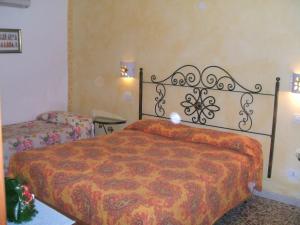 a bedroom with a bed with a orange blanket at Su Ghindalu Guesthouse in Villanova Monteleone
