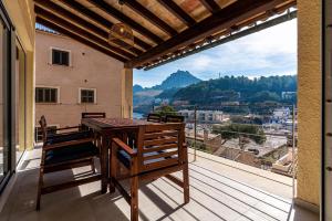 a wooden table and chairs on a balcony with a view at Lovely Central Apartment Guillem 3 Bedrooms Close To The Beach in Cala de Sant Vicent