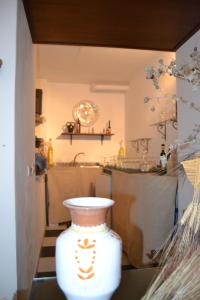 a white vase sitting on a table in a room at Su Ghindalu Guesthouse in Villanova Monteleone +53 photos