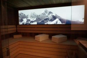 Una pantalla de televisión con montañas cubiertas de nieve. en ALPIUM - Luxusappartements en Flachau