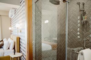 La salle de bains est pourvue d'une douche avec une porte en verre. dans l'établissement BIRD NEST at Sheikh Zayed, à Sheikh Zayed