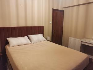 uma cama com duas almofadas brancas em cima em Ataviros Hotel em Émbonas