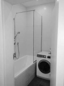 a bathroom with a shower and a washing machine at NEW Apartment - 10 min DOWNTOWN in Vienna
