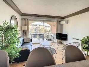 ein Wohnzimmer mit Sofa und Tisch in der Unterkunft Port Marine - T3 calme, avec terrasse, piscine, près de la plage in Sainte-Maxime