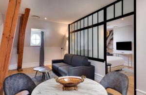 sala de estar con sofá, mesa y sillas en Alexandra Palace - La Maison Younan en Mazières-en-Gâtine
