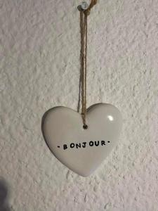 a white heart hanging from a ceiling with the words born out at Maison D Santa Giulia in Porto-Vecchio