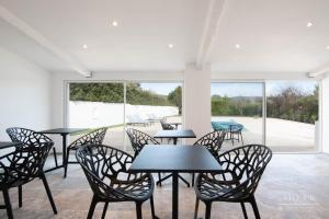 - un groupe de tables et de chaises dans une chambre avec piscine dans l'établissement Villa B, à Salernes