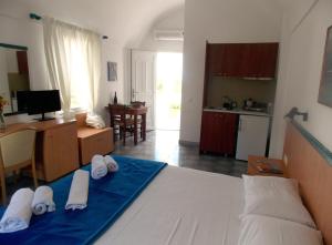 a bedroom with a bed and a kitchen with a table at Sunrise Studios in Perissa in Perissa