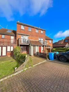 une maison en briques avec une voiture garée devant elle dans l'établissement Sea View Apartment Poole Quay - FREE Parking, à Poole