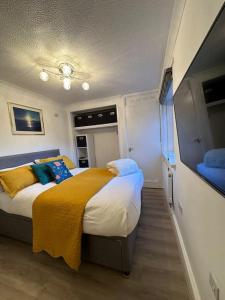 a bedroom with a bed with a yellow blanket at Sea View Apartment Poole Quay - FREE Parking in Poole