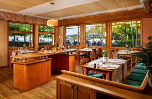 a restaurant with tables and chairs and windows at Hotel Restaurant Schiff in Pfäffikon