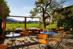 a patio with tables and chairs with a view of a field at Hotel Restaurant Schiff in Pfäffikon