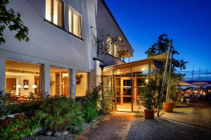 un edificio con porte in vetro e un patio di notte di Hotel Restaurant Schiff a Pfäffikon