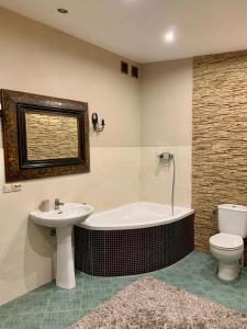 ein Badezimmer mit einer Badewanne, einem WC und einem Waschbecken in der Unterkunft Apartament z tarasem w Augustowie in Augustów