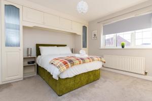a bedroom with a large bed and a window at Redgrave Detached home with free parking 4 minutes from City Walls in York