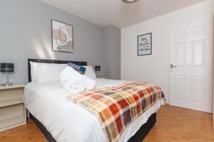a bedroom with a large white bed and a desk at Redgrave Detached home with free parking 4 minutes from City Walls in York