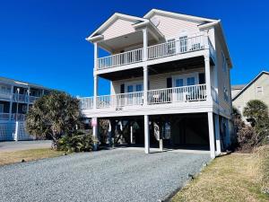 a large house with a balcony and a driveway at 2 the C in Holden Beach