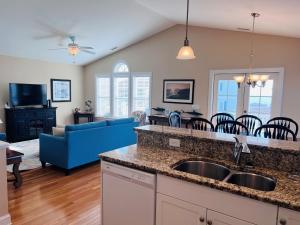 a kitchen and living room with a sink and a couch at 2 the C in Holden Beach