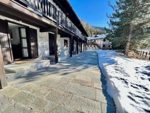 a snow covered sidewalk in front of a building at Chalet le Pigne Gressoney Saint Jean in Gressoney-Saint-Jean