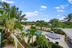 una piscina con palmeras y un complejo en Capri Inn & Apartments, en Lake Worth