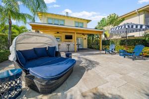 un patio trasero con un sofá y sillas y una casa en Capri Inn & Apartments, en Lake Worth