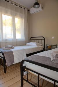 sypialnia z 2 łóżkami i oknem w obiekcie Lila's villa maisonette with private pool w mieście Nerotriviá