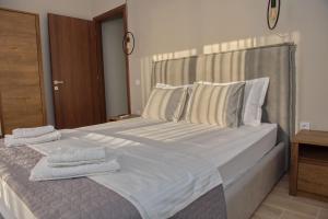 a bedroom with a large bed with towels on it at Lila's villa maisonette with private pool in Nerotriviá