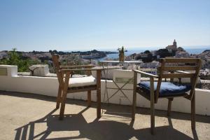 2 Stühle und ein Tisch auf einem Balkon mit Aussicht in der Unterkunft Arrels Hotel Cadaques - Adults Only in Cadaqués