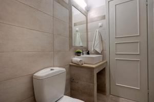 a bathroom with a toilet and a sink at Nissaki Sea View 201 by Sealand Villas in Nisakion +13 photos