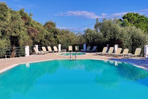 a swimming pool with chairs and a bunch of blue water at Nissaki Sea View 201 by Sealand Villas in Nisakion