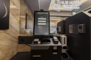 a computer monitor on top of a desk with a phone at Hubhotel Benqiao Inn Far Eastern Branch in Taipei