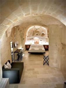a bedroom with a bed in a stone wall at CASA VACANZE BB 164-166 in Matera