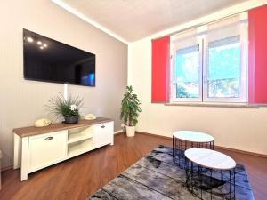 a living room with two chairs and a flat screen tv at Ferienwohnung "Rosental" in Stützengrün