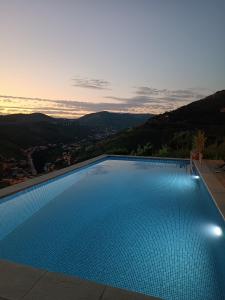 a swimming pool with a view of the mountains at Casa do Romezal in Peso da Régua