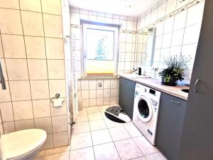 een badkamer met een wasmachine en een wastafel bij Ferienwohnung "Rosental" in Stützengrün