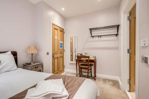 a bedroom with a bed and a desk with a chair at Central Belfast Apartments Harpers in Belfast