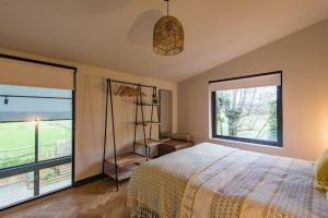 a bedroom with a bed and a large window at The Barn in Sandwich