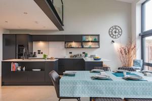 a kitchen and dining room with a blue table and chairs at The Barn in Sandwich +22 photos