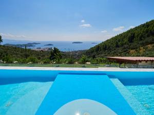 una piscina azul con vistas al océano en Sky Sea Resort & Villas, en Skiathos