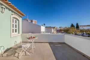 a patio with a table and chairs on a balcony at RG Casa do Carmo in Faro