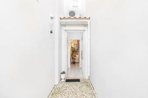 einen Korridor eines weißen Hauses mit einem weißen Flur in der Unterkunft RG Casa do Carmo in Faro